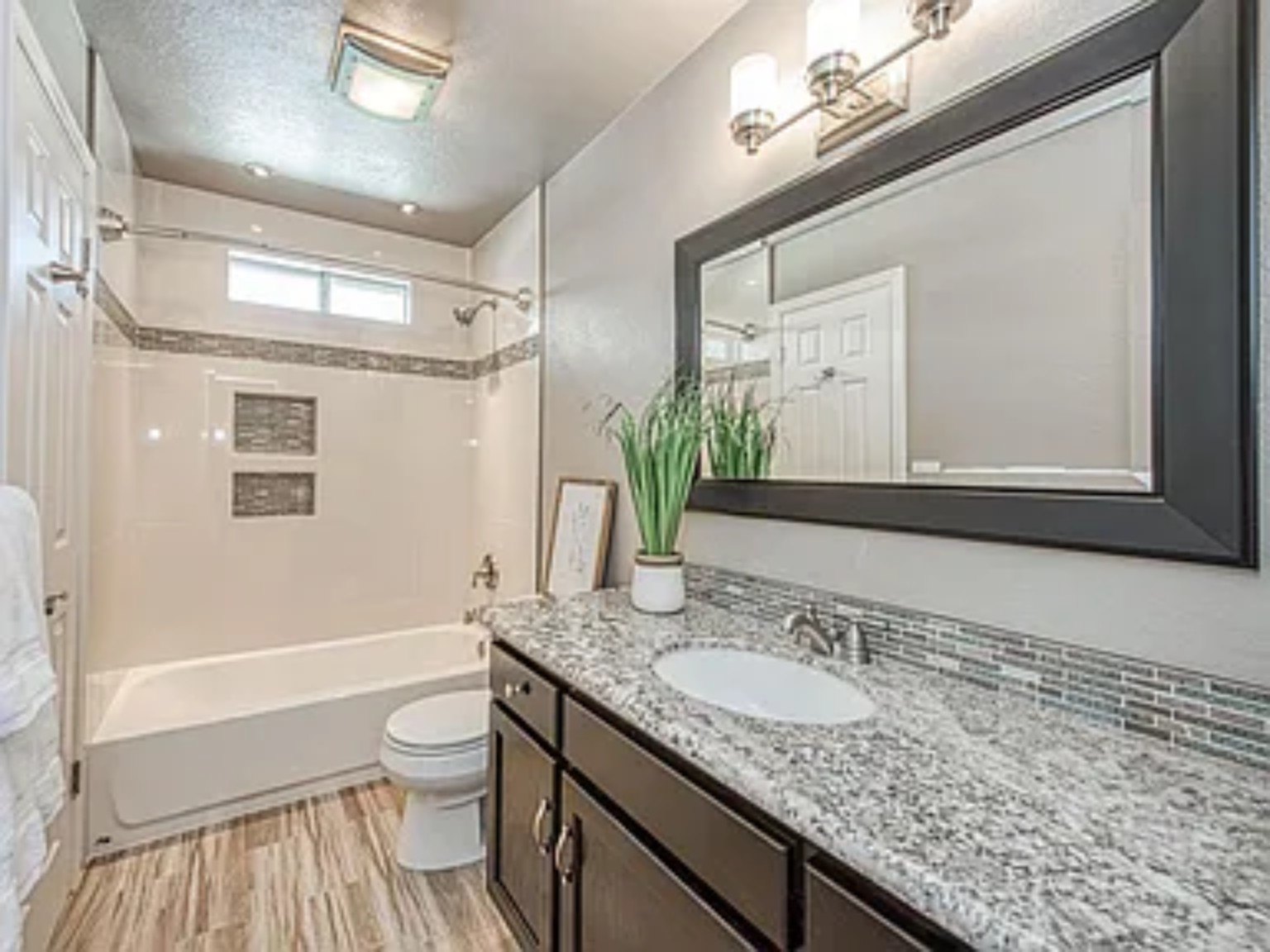 Finished bathroom with vanity, tub surround and coordinated finishes