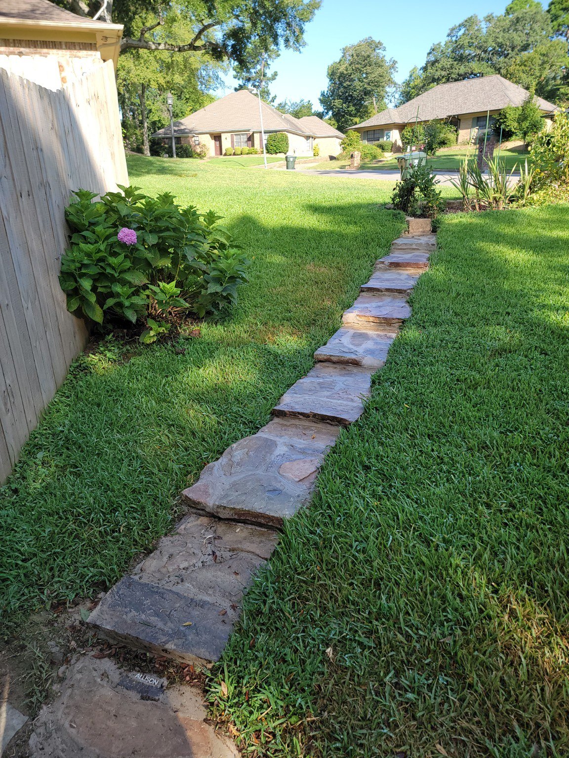 Curved stone walkway through residential landscaping