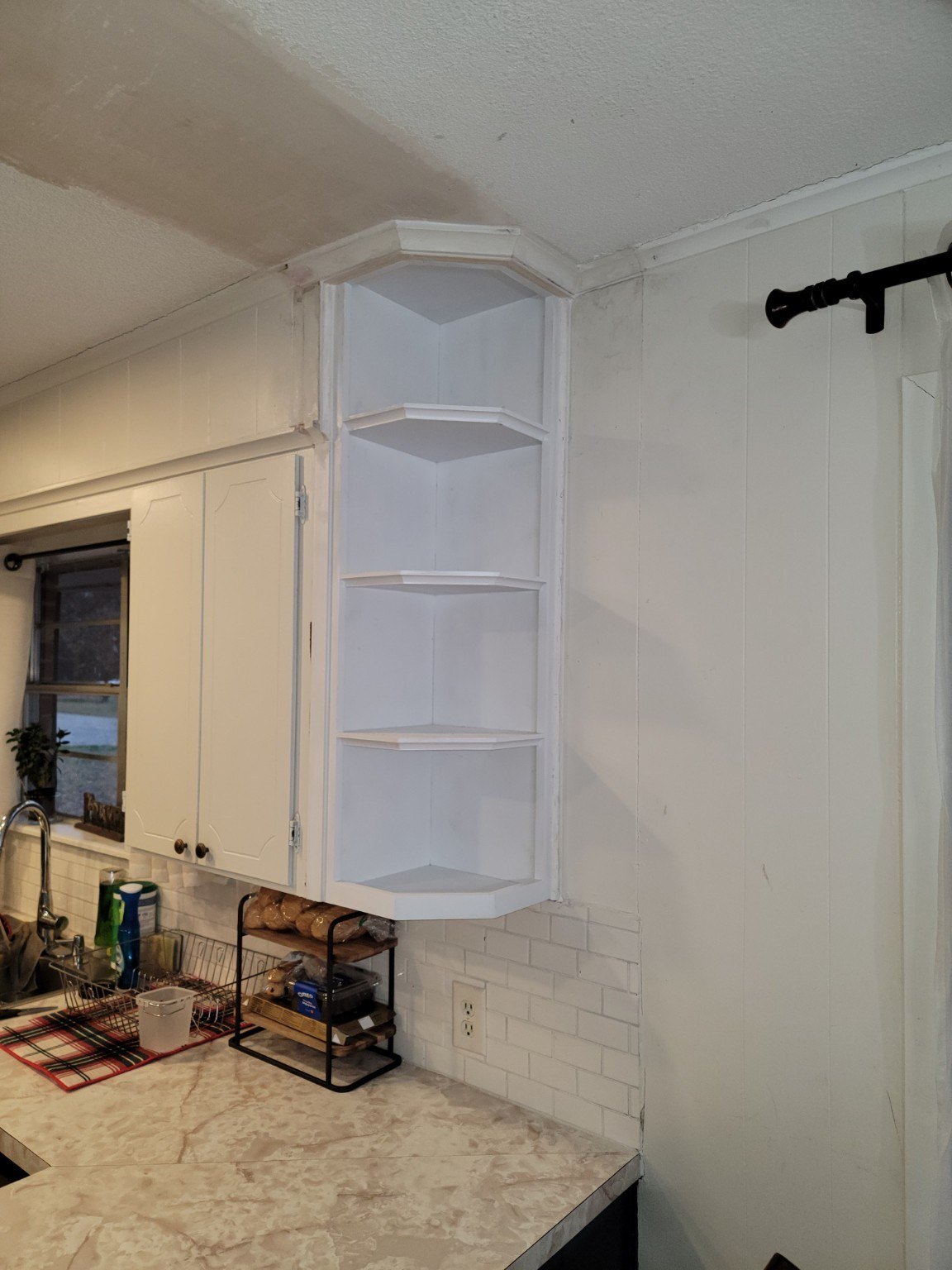 White custom corner shelving fitted into a kitchen
