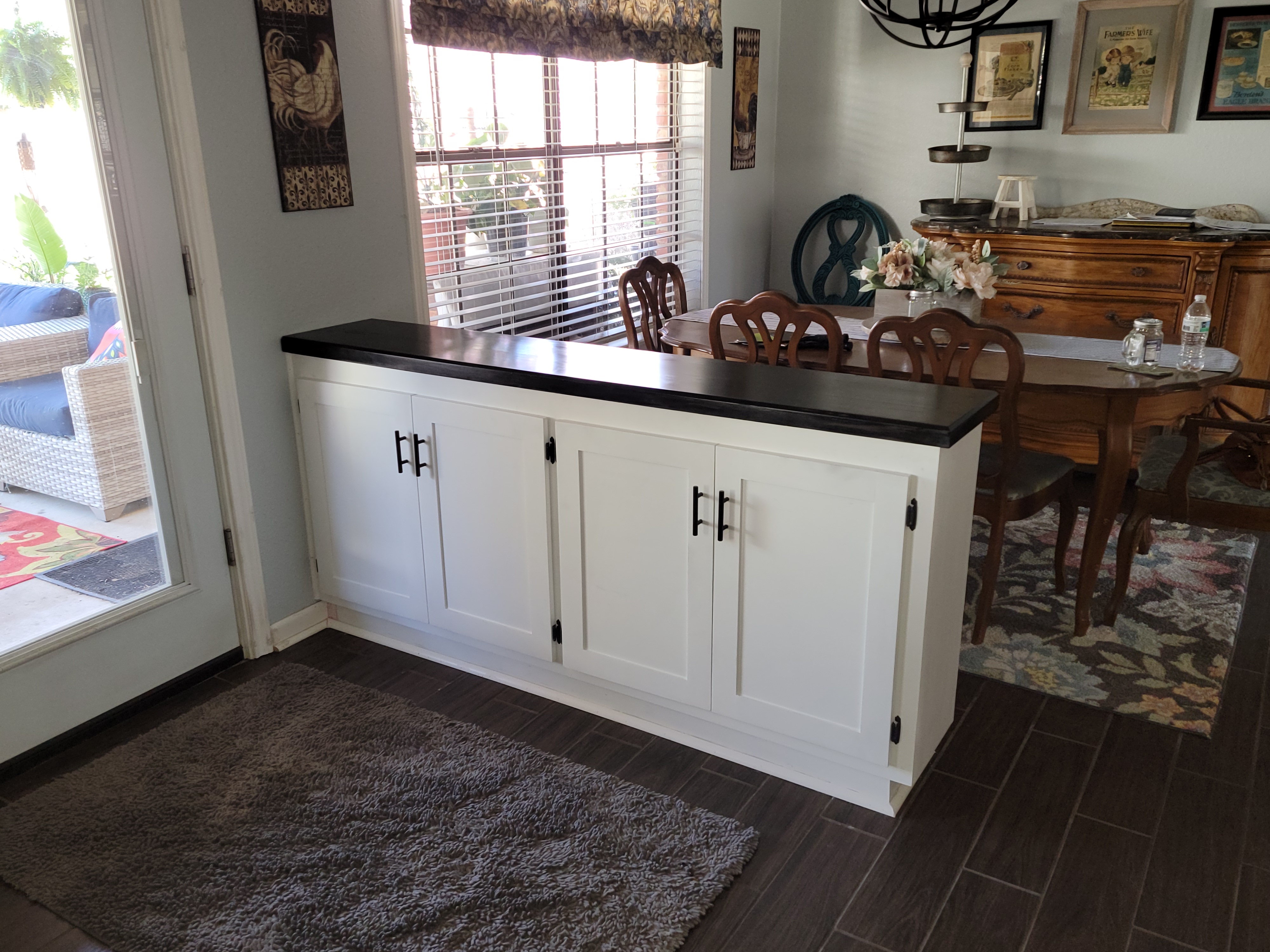 White custom buffet cabinet with dark countertop and black hardware